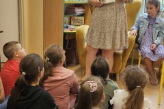 zdjęcie przedstawia  uczniów kasy 3b w trakcie akcji Czytanie na dywanie